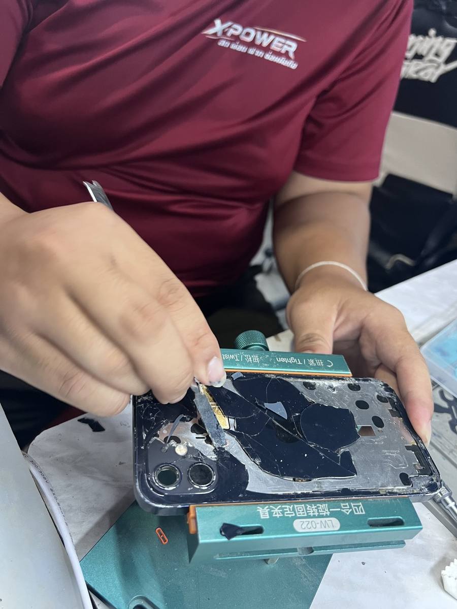 ช่างกำลังซ่อมเครื่อง iPhone ที่ร้าน X-POWER
